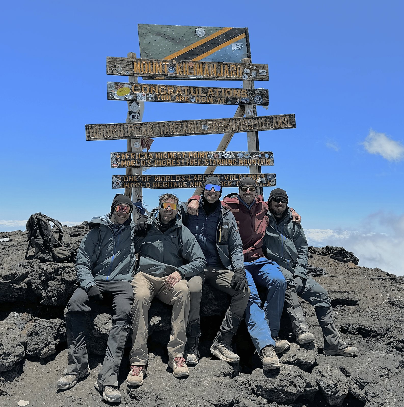 Five OIC founders at the Uhuru Peak summit sign on Mount Kilimanjaro.